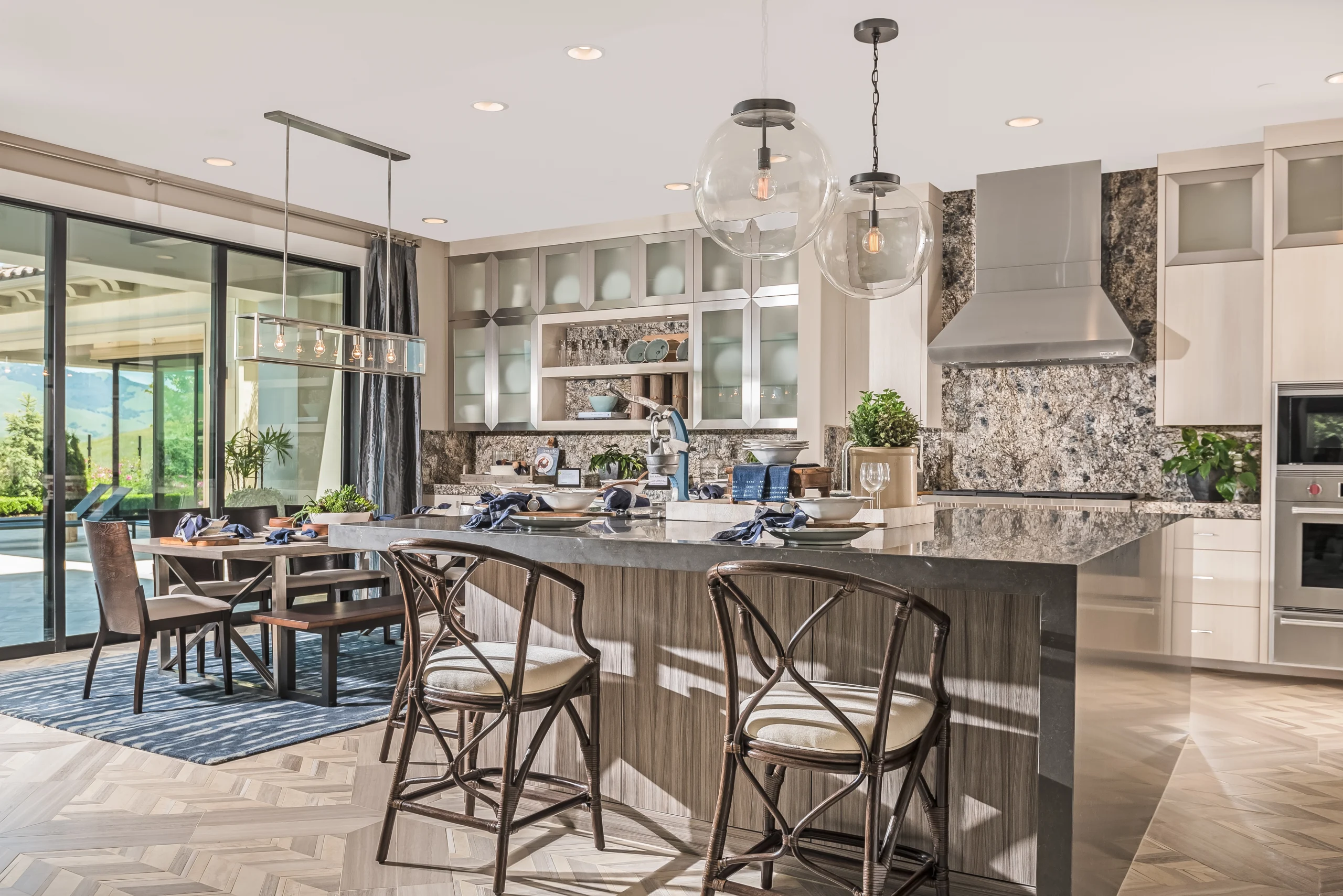 Open-concept kitchen with waterfall stone island and patterned tile floor
