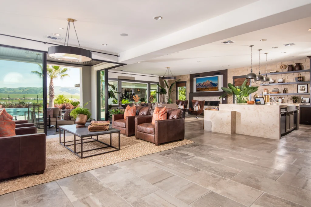 Open-concept living space with stone flooring, custom tile wall, and solid surface island by Hometown Stone.